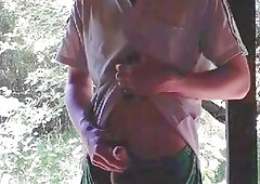 Beefy young man jerks off in an abandoned shed wearing skimpy swim trunks