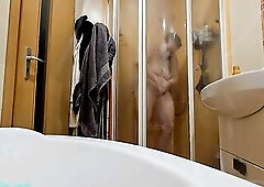 A breasty big beautiful woman showering in the shower cabin, shaving her armpits, snatch, and legs