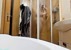 A breasty big beautiful woman showering in the shower cabin, shaving her armpits, snatch, and legs