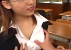 Innocent looking Japanese teacher with huge titties giving a hot handjob to her student