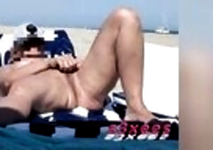 That babe masturbates her on a naturist beach in public. A great exhibition with his legs wide apart in full view of everybody. A voyeur passes by wit