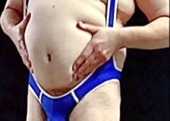 Mature coach with massive belly suits up in a tight singlet and shows off his bulge