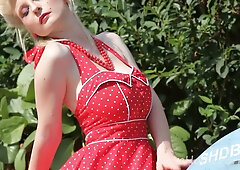 Blonde pornstar Casey Deluxe strips down in a red polka-dot dress beside a vintage motorcycle