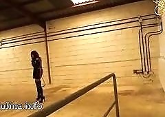 Mistress in high heels readies her whip for BDSM slave