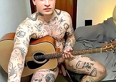 Naked Tattooed Guy Showing Off His Ass and Playing a Guitar