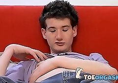 Young man touches his feet while rubbing his meaty dick