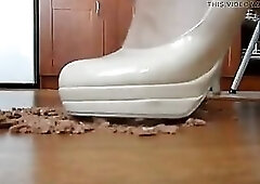 Crushing Corn Flakes! Miss Anastasia crushes with its cream-colored high heels a lot of brown flakes. The brown mush trampled on the ground then u nee