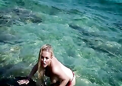 Jena Fascinating, the breathtaking blond model, effortlessly captures the essence of summer as that babe positions in a vibrant red bikini against the