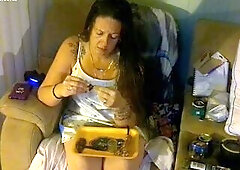 Breasty beauty in pink brassiere and pants smokin' and playing movie games