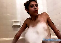 A blonde, amateur Latina babe with a bubbly personality and a hairy pussy, long legs, and white toes teases and soothes herself in a bubble bath, smil