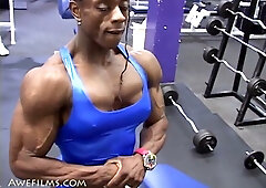 Muscular woman and man showcase defined physiques in intense gym workout