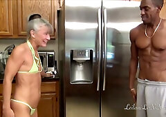Gray-haired granny and blonde babe in bikinis worship Jonathan Jordan's cock in the kitchen before sharing a facial